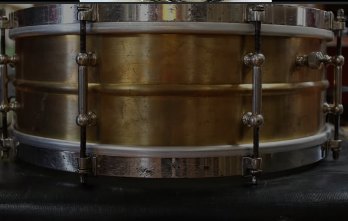 The same Leedy brass snare before restoration, shell dull and mottled with heavy tarnish and grime