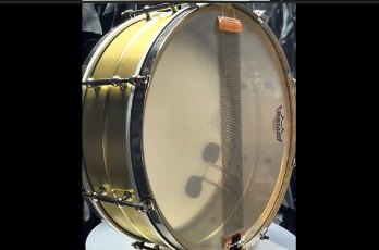 Snare side of the drum after restoration, showing the resonant head and snare wires across the snare bed